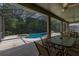 Serene screened-in pool area with covered patio seating, offering a relaxing and private outdoor space with lush greenery at 4697 Golden Beach Ct, Kissimmee, FL 34746
