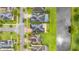 Overhead view of neighborhood houses along a street, some with pools, nestled between lawns and a pond at 4952 Creekside Park Ave, Orlando, FL 32811