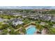 An aerial shot of the neighborhood featuring a pool, clubhouse, manicured landscaping and consistent architectural design at 4952 Creekside Park Ave, Orlando, FL 32811