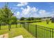Scenic backyard view with lush green grass, a pond, and a black metal fence at 4952 Creekside Park Ave, Orlando, FL 32811