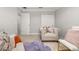 Neutral toned bedroom with stylish chair, soft carpet and closet at 4952 Creekside Park Ave, Orlando, FL 32811