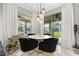 Bright dining area featuring a modern chandelier, sleek white table, and access to the outdoor space at 4952 Creekside Park Ave, Orlando, FL 32811