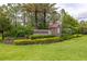 Landscaped Millennia Park entrance sign with stone accents surrounded by vibrant green grass and manicured hedges at 4952 Creekside Park Ave, Orlando, FL 32811