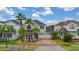 An elevated view of a landscaped two-story home with a brick driveway and a three-car garage at 4952 Creekside Park Ave, Orlando, FL 32811