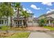 Inviting two-story home featuring a three-car garage, front porch, and lush landscaping with palm trees at 4952 Creekside Park Ave, Orlando, FL 32811