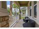 A furnished front porch featuring stone columns, a seating area, and views of neighboring homes at 4952 Creekside Park Ave, Orlando, FL 32811