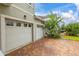 Side angle view of a three car garage with a brick driveway at 4952 Creekside Park Ave, Orlando, FL 32811
