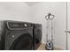Modern laundry room with black appliances and accessories at 4952 Creekside Park Ave, Orlando, FL 32811