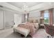An elegant main bedroom offers large windows, chandelier, and tufted headboard at 4952 Creekside Park Ave, Orlando, FL 32811