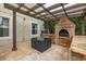 Covered outdoor kitchen with a brick grill, dining table, and granite countertops at 4952 Creekside Park Ave, Orlando, FL 32811