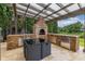 Full outdoor kitchen with a stainless fridge, granite countertops, and a dining table at 4952 Creekside Park Ave, Orlando, FL 32811