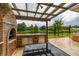 Outdoor kitchen with a brick pizza oven, grill, and countertop space overlooking the water at 4952 Creekside Park Ave, Orlando, FL 32811