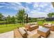 Relaxing patio area showcasing wicker furniture and serene views of the tranquil lake behind a black metal fence at 4952 Creekside Park Ave, Orlando, FL 32811