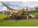 Community playground featuring a variety of equipment, and sun shades surrounded by lush landscaping at 4952 Creekside Park Ave, Orlando, FL 32811
