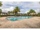 Community pool featuring brick perimeter, lounge chairs, palm trees, and shaded seating areas, perfect for relaxation at 4952 Creekside Park Ave, Orlando, FL 32811