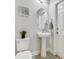 Cozy powder room showcases pedestal sink, art, and convenient towel rack near the door at 515 Everest Way, Kissimmee, FL 34758