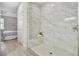 Bathroom with marble-look tiled shower with bench and wood-look tile floor at 515 Everest Way, Kissimmee, FL 34758