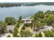 Aerial view of a waterfront home surrounded by trees and lush landscaping at 550 Lake Otis Se Dr, Winter Haven, FL 33880