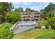 Aerial shot of contemporary home with pool, tiered deck, and lush, mature landscaping at 550 Lake Otis Se Dr, Winter Haven, FL 33880