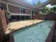 Backyard view with brick home, courtyard, pool, and small garden at 550 Lake Otis Se Dr, Winter Haven, FL 33880
