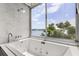 Luxurious bathroom features a large soaking tub with jets and a scenic lake view at 550 Lake Otis Se Dr, Winter Haven, FL 33880