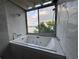 Large soaking tub featuring jets and expansive windows with views of the lake and sky at 550 Lake Otis Se Dr, Winter Haven, FL 33880