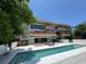 Contemporary home featuring a swimming pool and multiple balconies at 550 Lake Otis Se Dr, Winter Haven, FL 33880