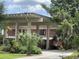 Front exterior with a covered entryway, brick facade, and lush landscaping at 550 Lake Otis Se Dr, Winter Haven, FL 33880