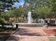 Serene brick-lined community fountain featuring multiple benches for relaxation under mature trees at 550 Lake Otis Se Dr, Winter Haven, FL 33880