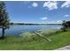 Serene view of a tranquil lake with a quaint, rustic dock surrounded by lush greenery at 550 Lake Otis Se Dr, Winter Haven, FL 33880