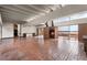 Expansive living room featuring a brick fireplace, brick floors, and serene lake views at 550 Lake Otis Se Dr, Winter Haven, FL 33880