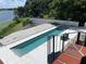 Private lap pool with retractable cover, surrounded by white tile and adjacent to a tranquil lake at 550 Lake Otis Se Dr, Winter Haven, FL 33880