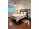 Spacious bedroom boasting a tufted headboard, plush bedding, and stylish hardwood flooring at 655 Vine Ct, Apopka, FL 32703