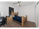 Bedroom featuring a ceiling fan, neutral walls, a double bed with blue sheets, and a wooden nightstand at 6651 Syreeta Ln, Harmony, FL 34773