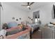 Cozy bedroom with neutral walls, a ceiling fan, a double bed with floral sheets, and a crib at 6651 Syreeta Ln, Harmony, FL 34773