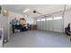 Spacious garage with gray epoxy flooring, overhead lighting, and ample storage, including a refrigerator at 6651 Syreeta Ln, Harmony, FL 34773