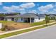 Low angle shot shows this home's rear exterior, gray shingles, solar panels, covered patio, and yard at 6651 Syreeta Ln, Harmony, FL 34773