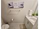 Stylish bathroom features modern vanity, humorous artwork, and pristine white fixtures at 7773 Spectrum Dr, Reunion, FL 34747