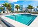 Community pool with lounge chairs, tropical landscaping, and clear blue skies at 7773 Spectrum Dr, Reunion, FL 34747