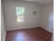 Clean bedroom with a window, hardwood floors and a wall-mounted air conditioning unit at 822 5Th St, Orlando, FL 32824