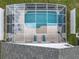 Aerial view of a screened-in pool and patio area with outdoor furniture and green landscaping at 824 Bloomingdale Dr, Davenport, FL 33897