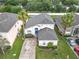 Aerial view showcasing the front of the home, with a blue front door, landscaping, and a driveway at 824 Bloomingdale Dr, Davenport, FL 33897