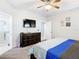 Neutral bedroom featuring a ceiling fan, dark dresser, and television at 824 Bloomingdale Dr, Davenport, FL 33897