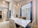 Bright dining room showcasing a chandelier, high ceilings, a large table, and access to the front entrance at 824 Bloomingdale Dr, Davenport, FL 33897