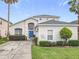 Charming two-story home boasting a blue front door, well-manicured lawn, and lush landscaping at 824 Bloomingdale Dr, Davenport, FL 33897