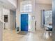 Inviting foyer with a high ceiling, bright blue front door, tiled flooring, and natural light at 824 Bloomingdale Dr, Davenport, FL 33897