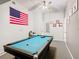Fun game room offers a light blue pool table under a fan, plus wall art and an American flag at 824 Bloomingdale Dr, Davenport, FL 33897