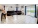 Spacious living room with tiled floors, comfortable leather seating, and sliding glass doors leading to the pool area at 824 Bloomingdale Dr, Davenport, FL 33897