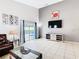 Bright living room with access to patio and pool, featuring tiled floors and gray accent wall at 824 Bloomingdale Dr, Davenport, FL 33897