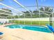 Refreshing in-ground pool is surrounded by a screened enclosure and furniture, great for entertaining at 824 Bloomingdale Dr, Davenport, FL 33897